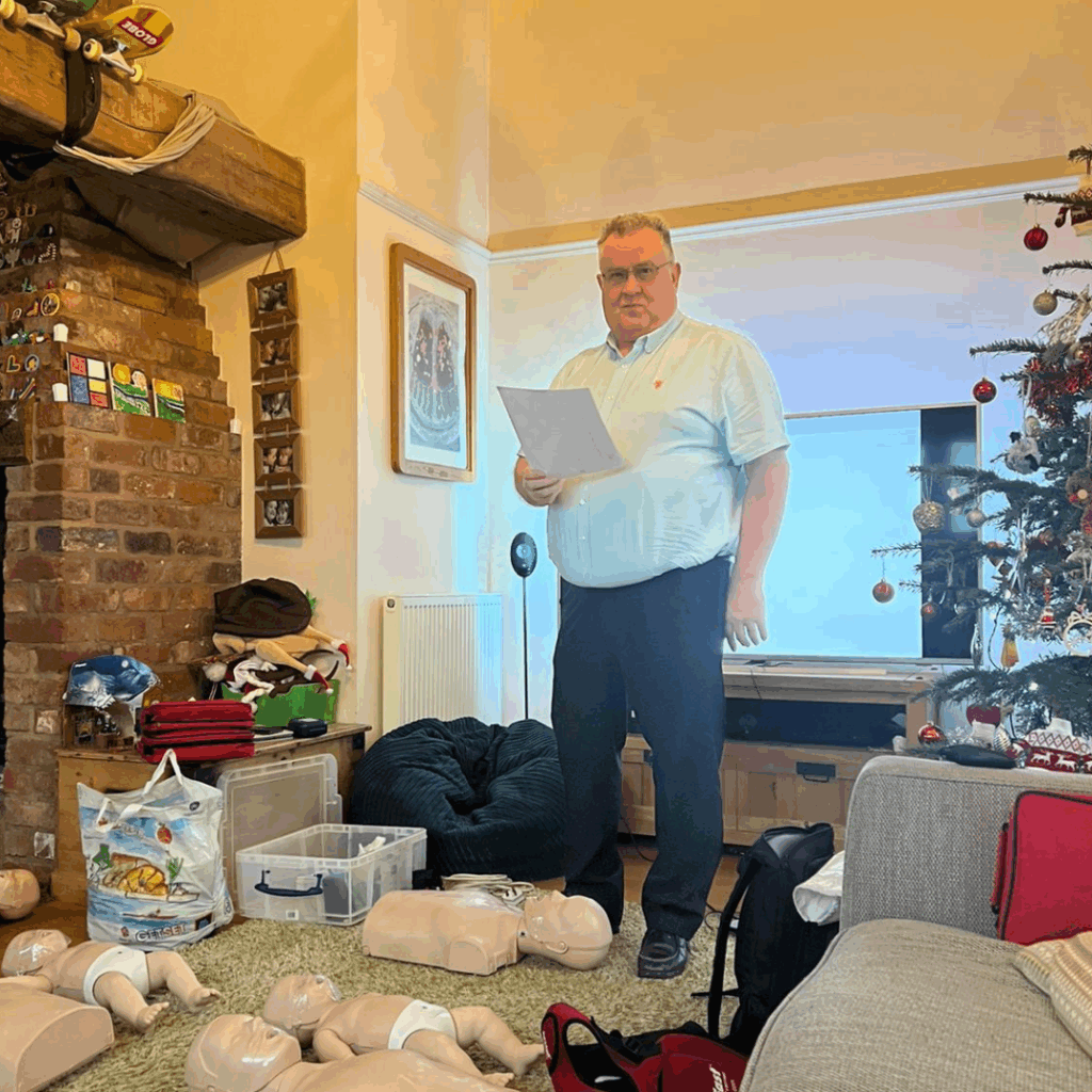 Bellstone Training instructor leading a first aid training session with CPR mannequins in a home setting.